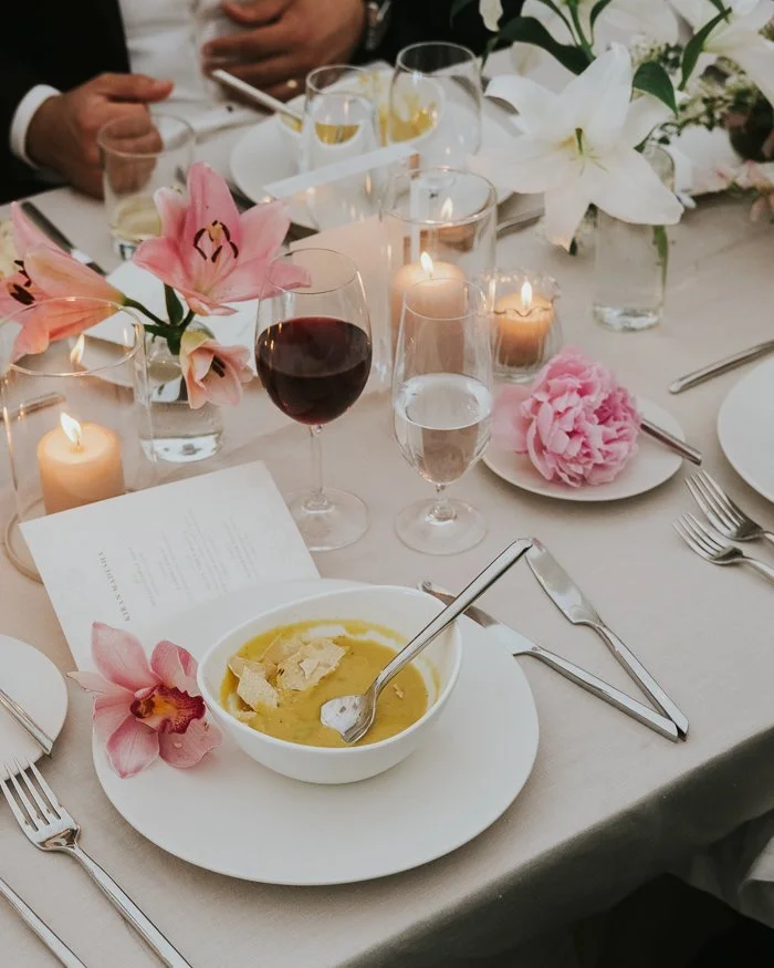 a bowl of yellow soup on a beautiful wedding table
