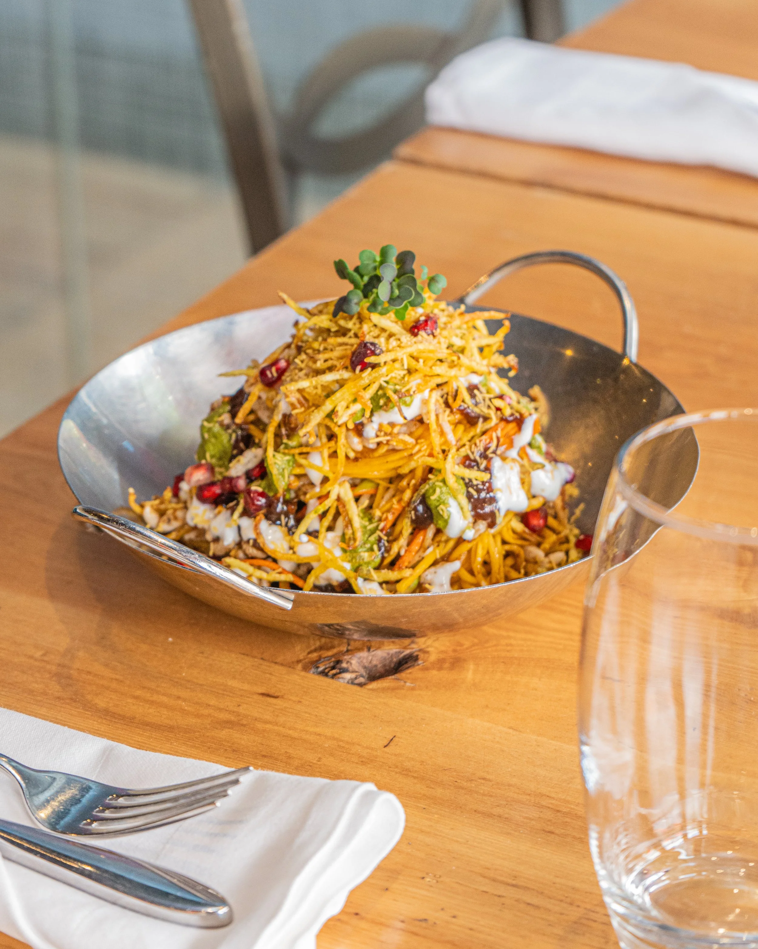 A metal bowl full of vibrant Pukka Chaat