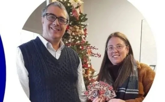 Two employees from RKM standing near a Christmas tree, holding gift cards, with text saying 'We love serving our community' and 'R.K Mooney donate to Big Brothers Big Sisters'. Contact details and website are included.