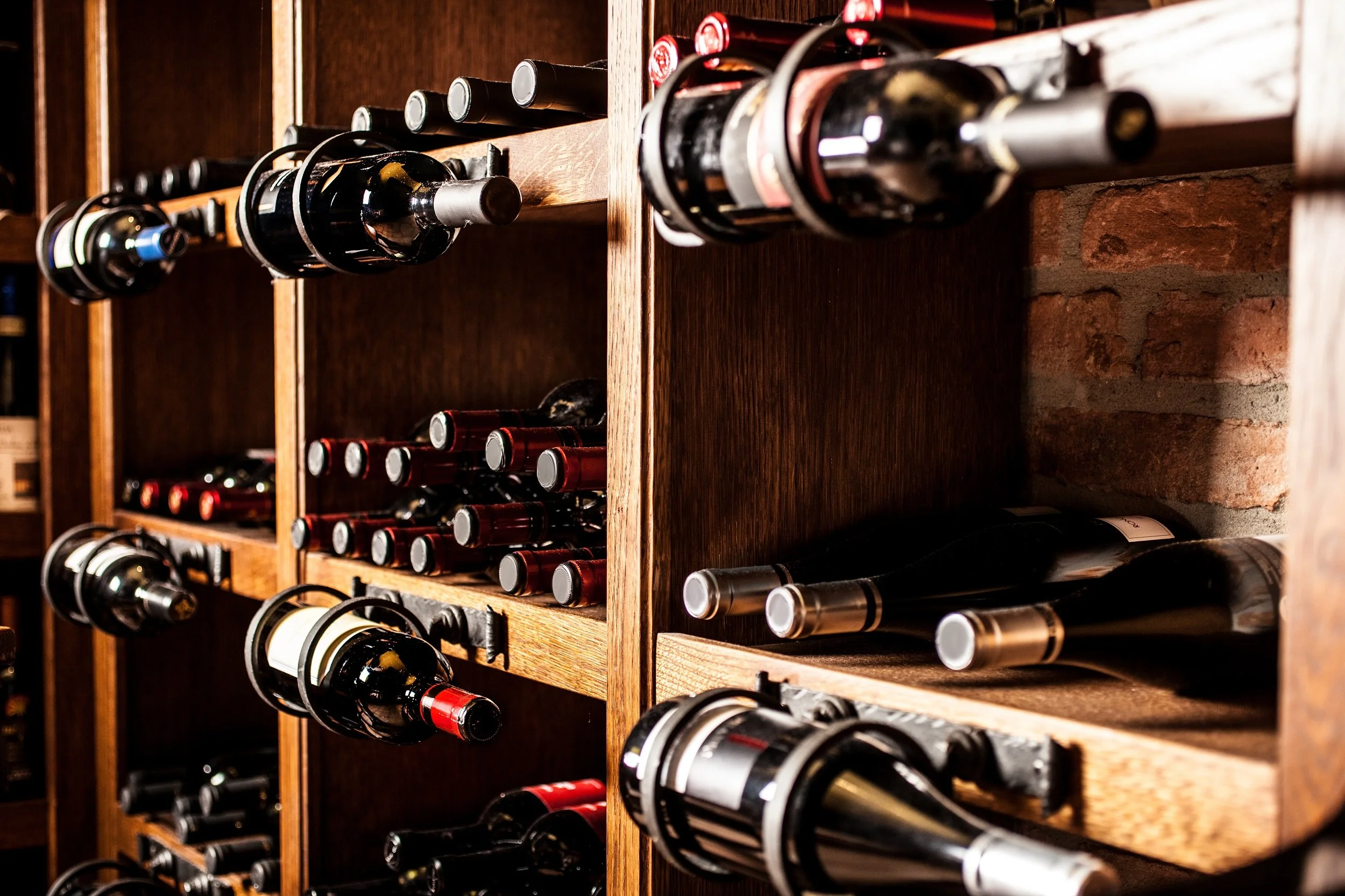 wine bottles on shelves of wine cellar