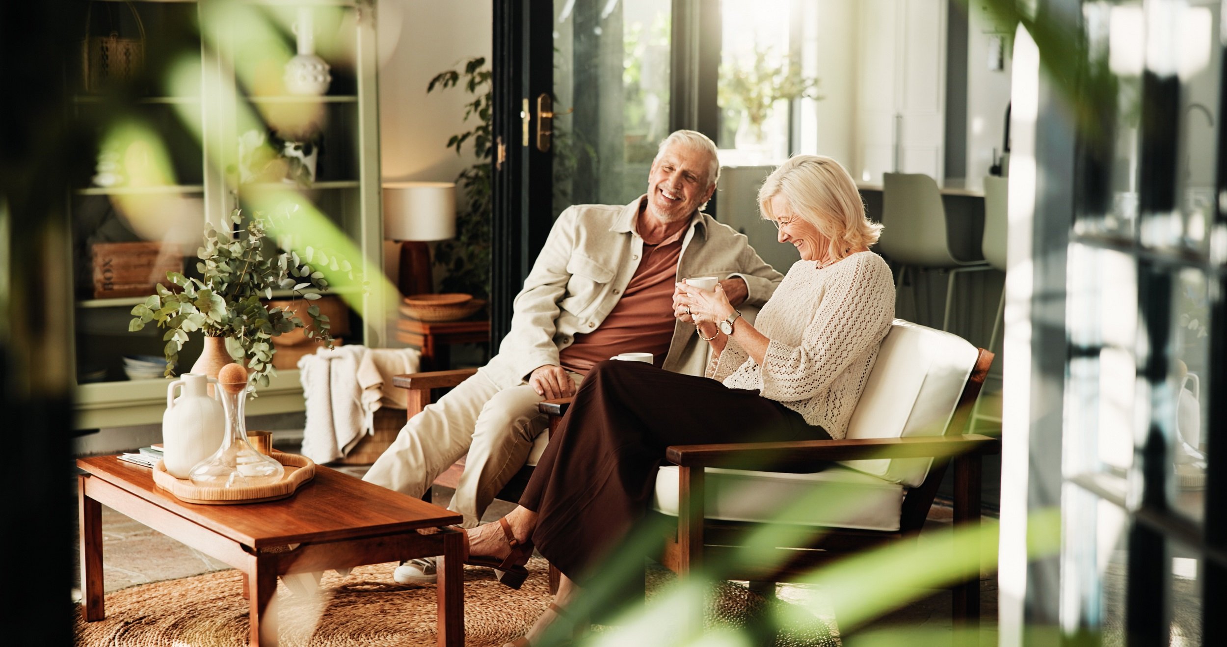 Happy senior couple enjoying coffee in interior living room