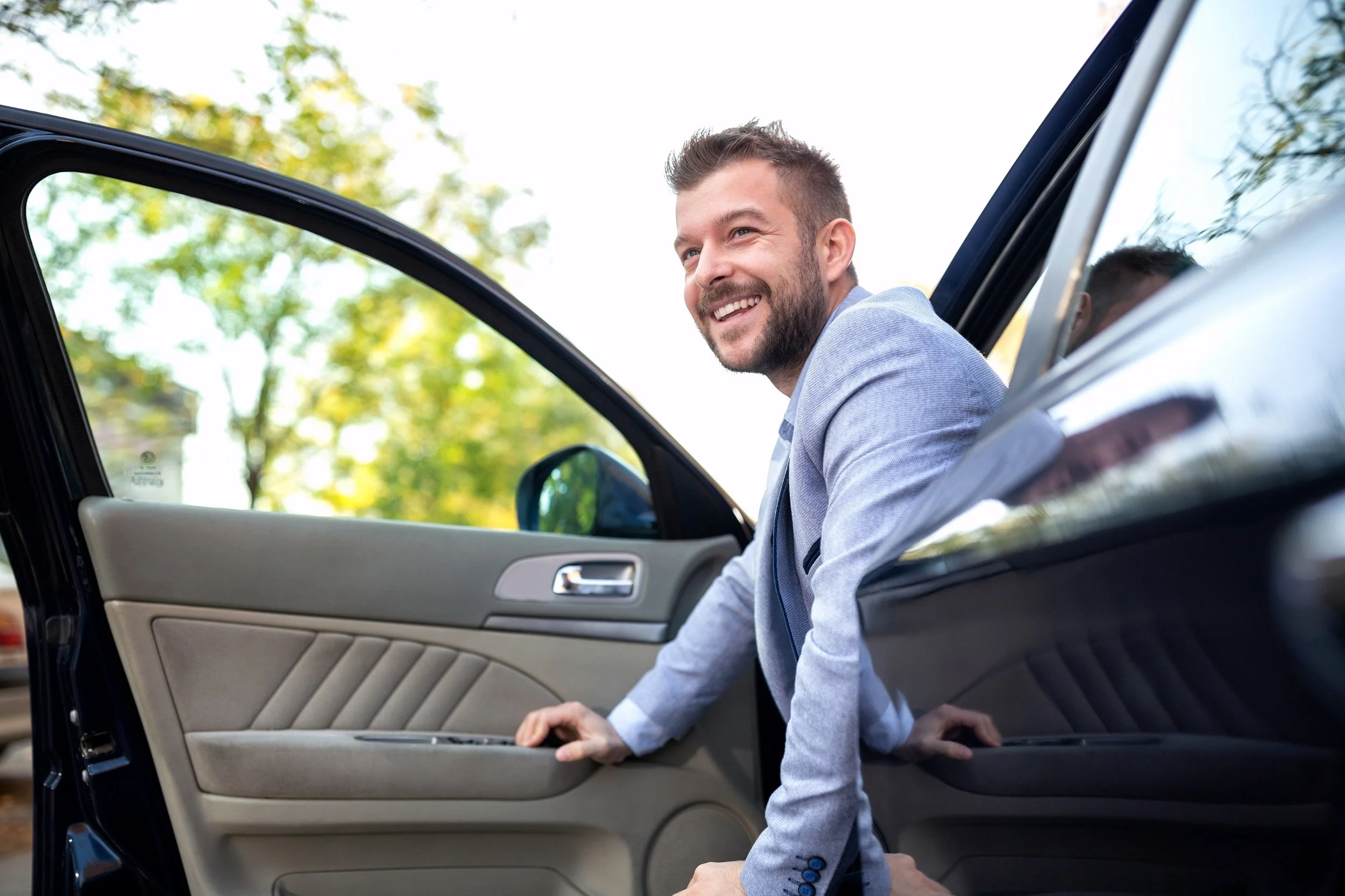 Smiling man exiting his luxury vehicle