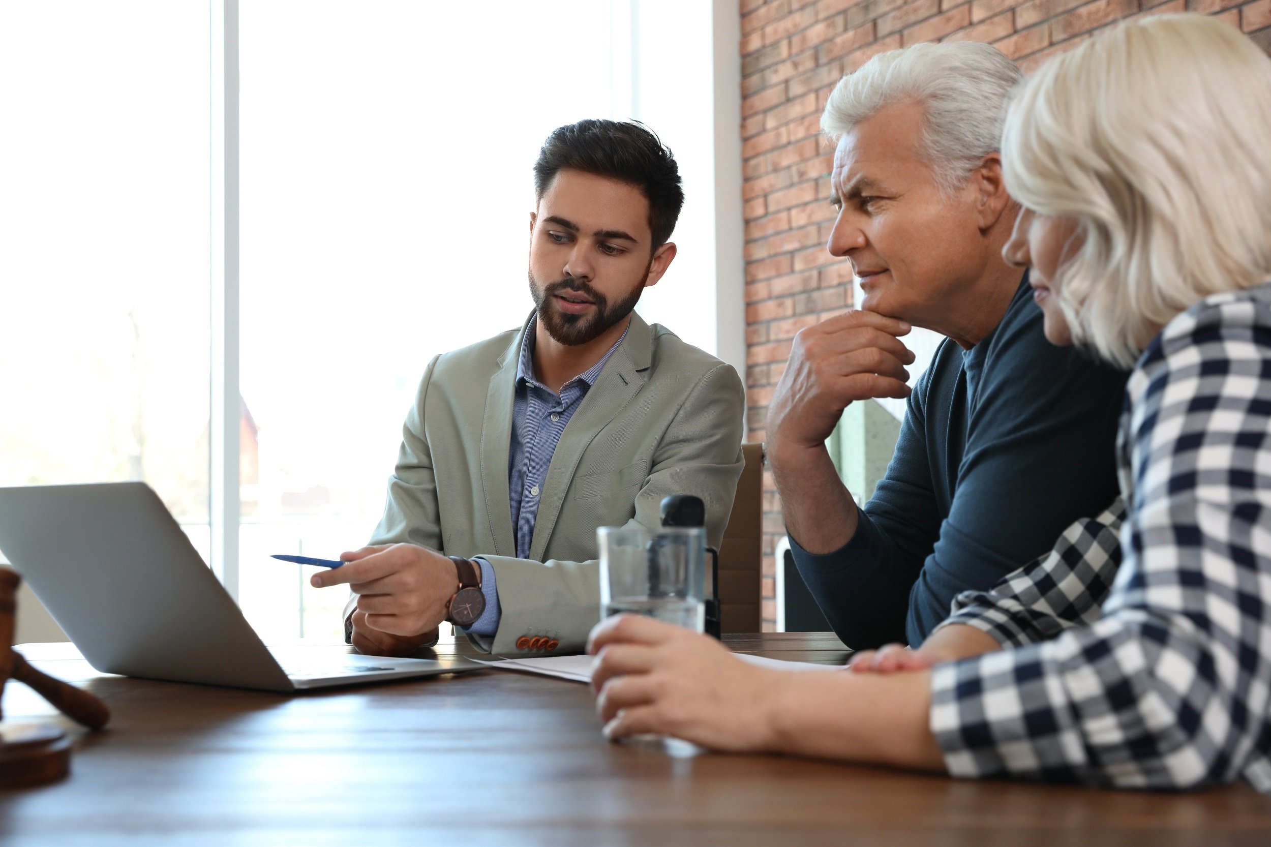 Male advisor working with mature couple in office