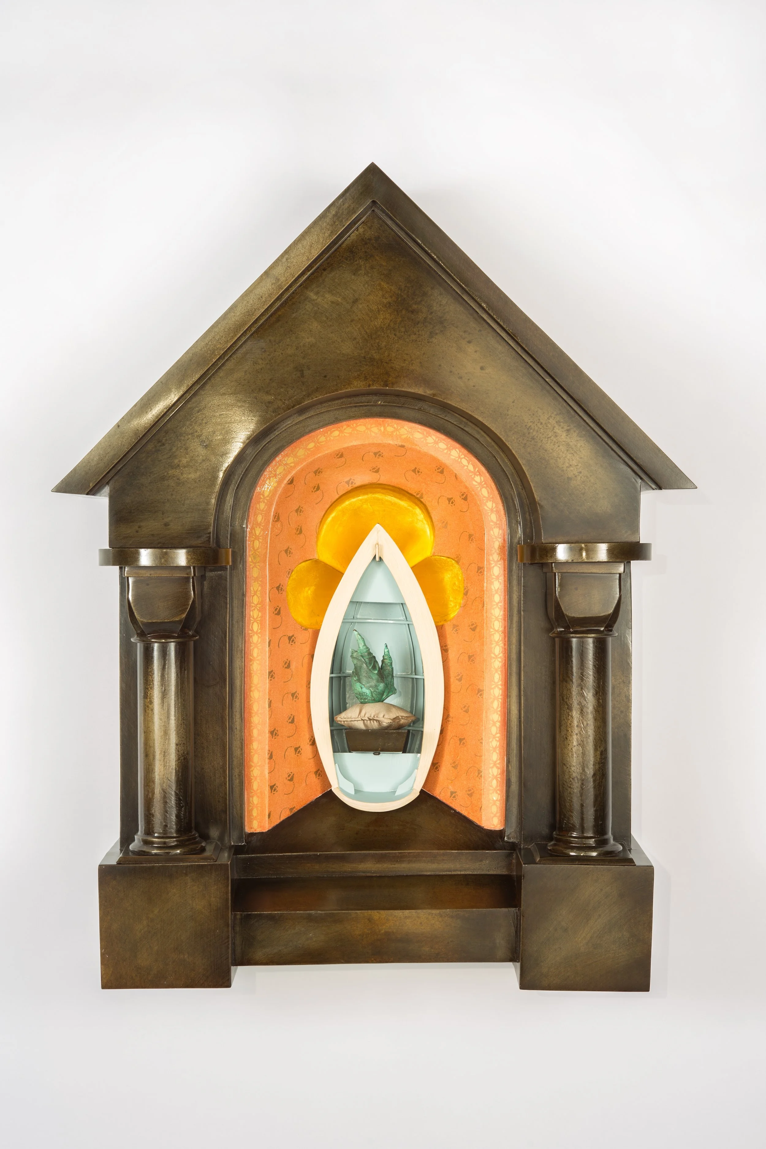 A daffodil bulb sits regally on a tiny silk pillow within a dory boat. The boat symbolizes one’s journey through life.