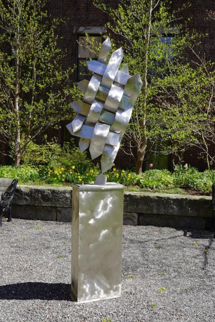 Stainless steel fence posts are sculpted in a basketweave pattern