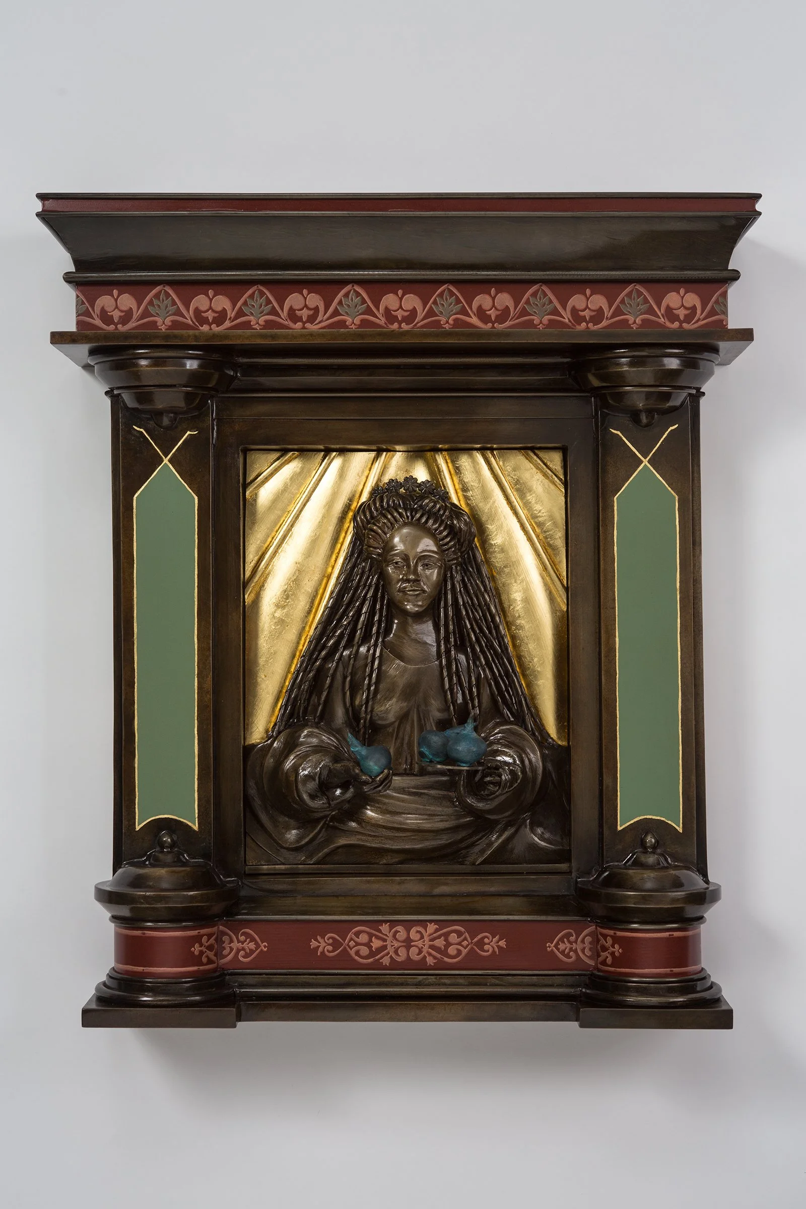 Magna Mater or The Great Mother holds three tulip bulbs. She presents the seeds of life out toward the viewer like a gift. These sculptural details signify life, birth, and new beginnings.