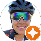 Close-up of a person wearing a bicycle helmet and reflective sunglasses, smiling
