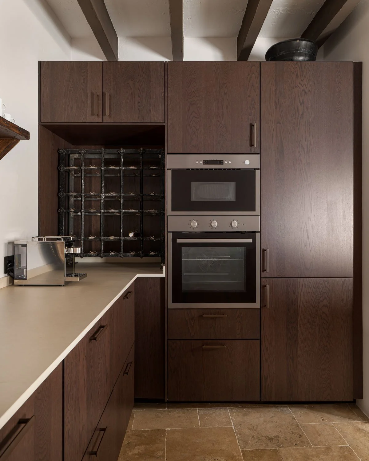 Kitchen interior with wrought iron wine cellar and built-in oven by Atelier Valencia