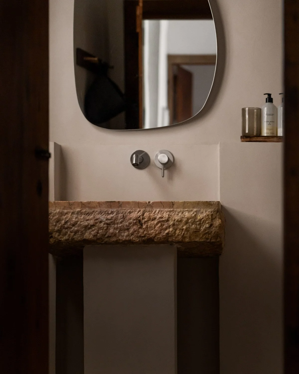Hand carved natural stone basin with brushed steel faucet in Altea townhouse bathroom