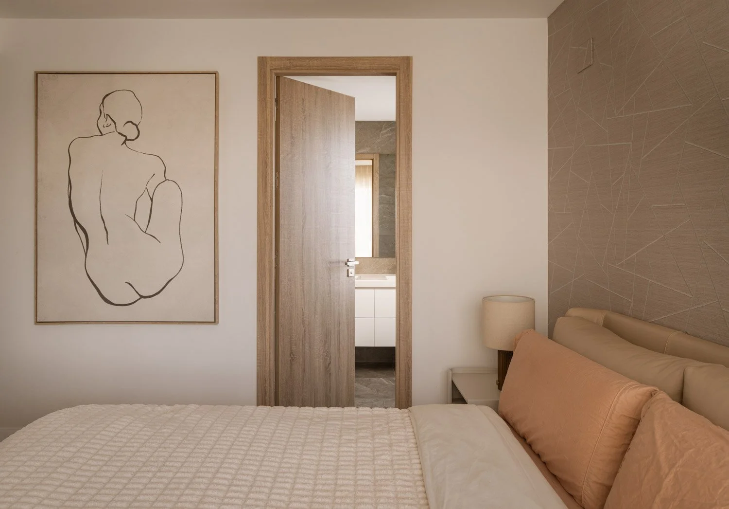 Neutral bedroom with line art canvas and an open ensuite bathroom.