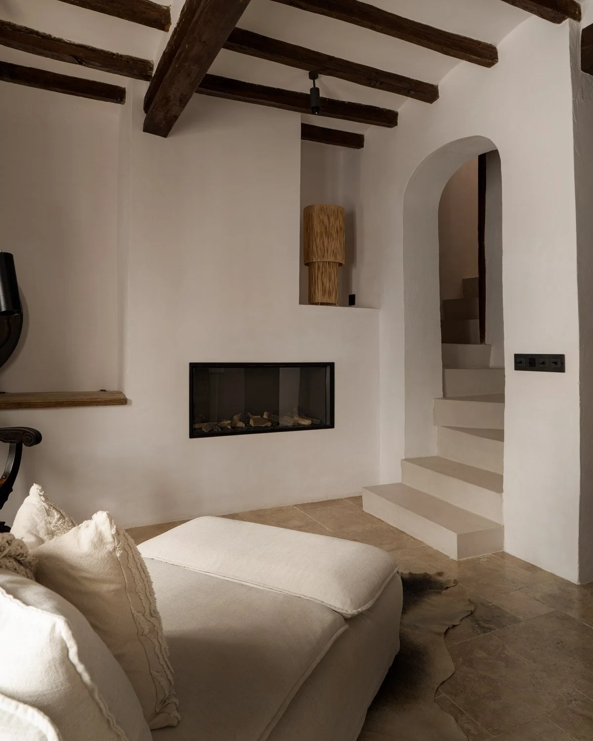 Living area with arched plaster staircase and linen sofa in Altea Costa Blanca residence