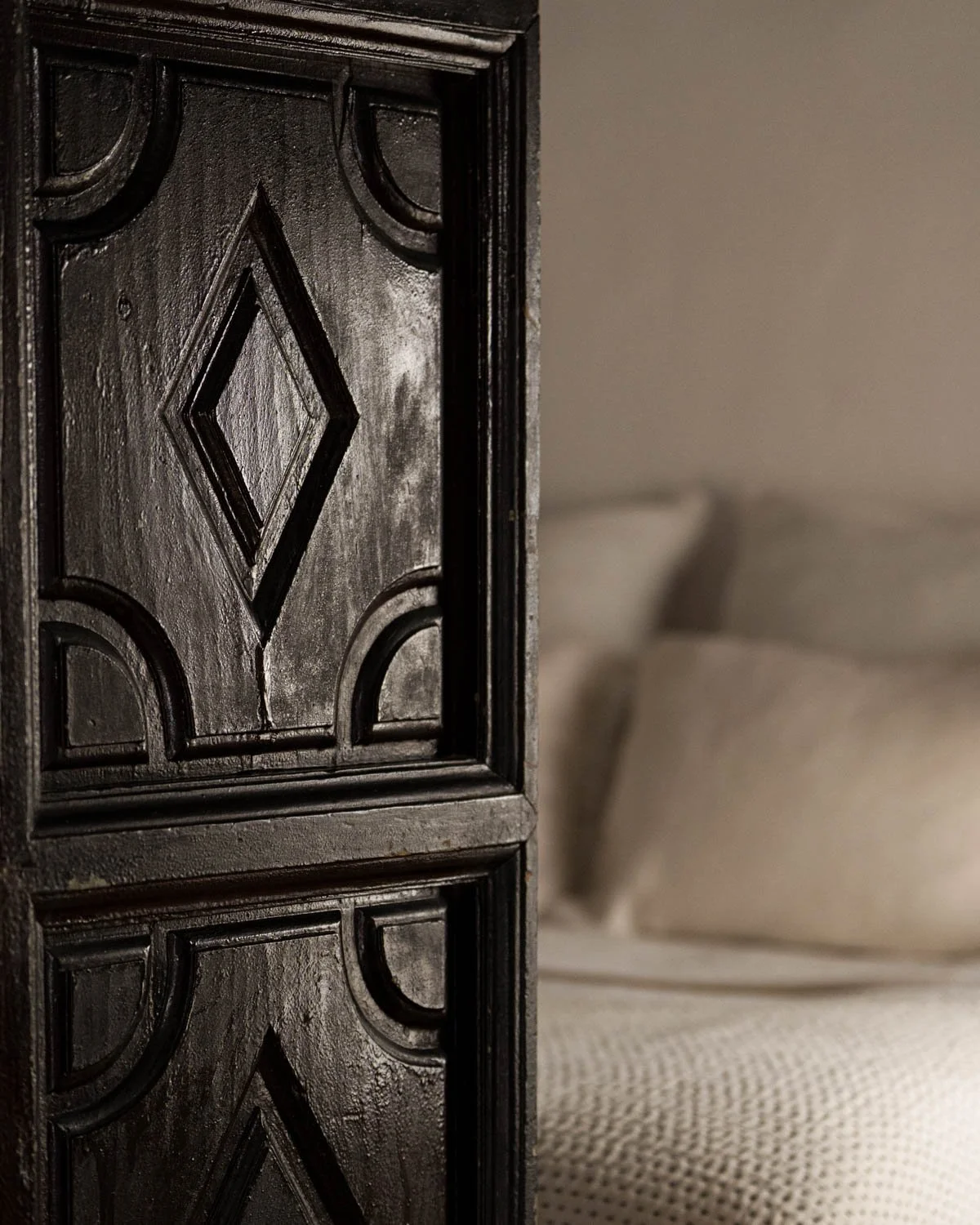 Detail of carved black wooden screen with diamond pattern in restored Altea bedroom