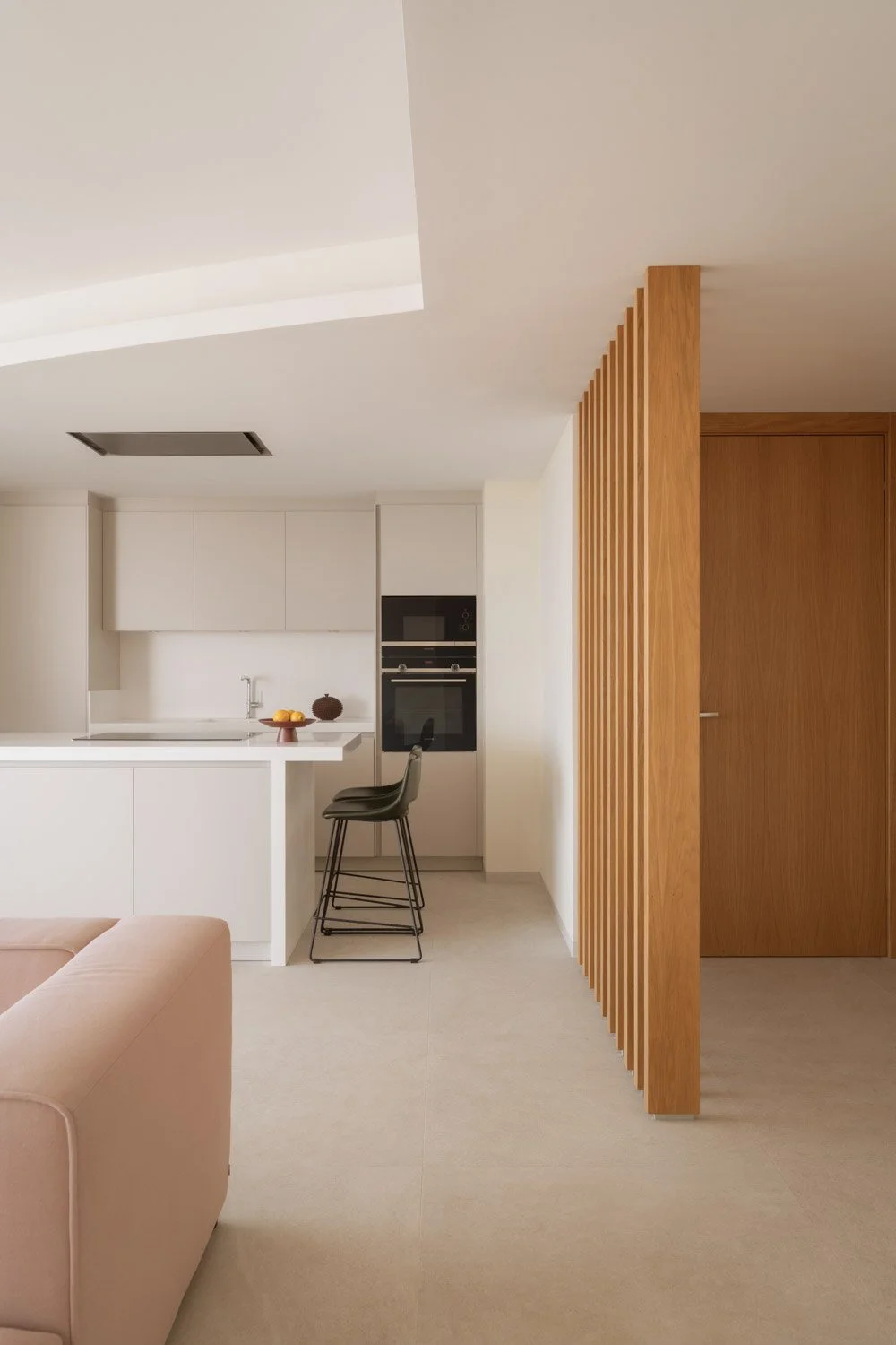 Open kitchen and living area separated by a wooden slat divider.