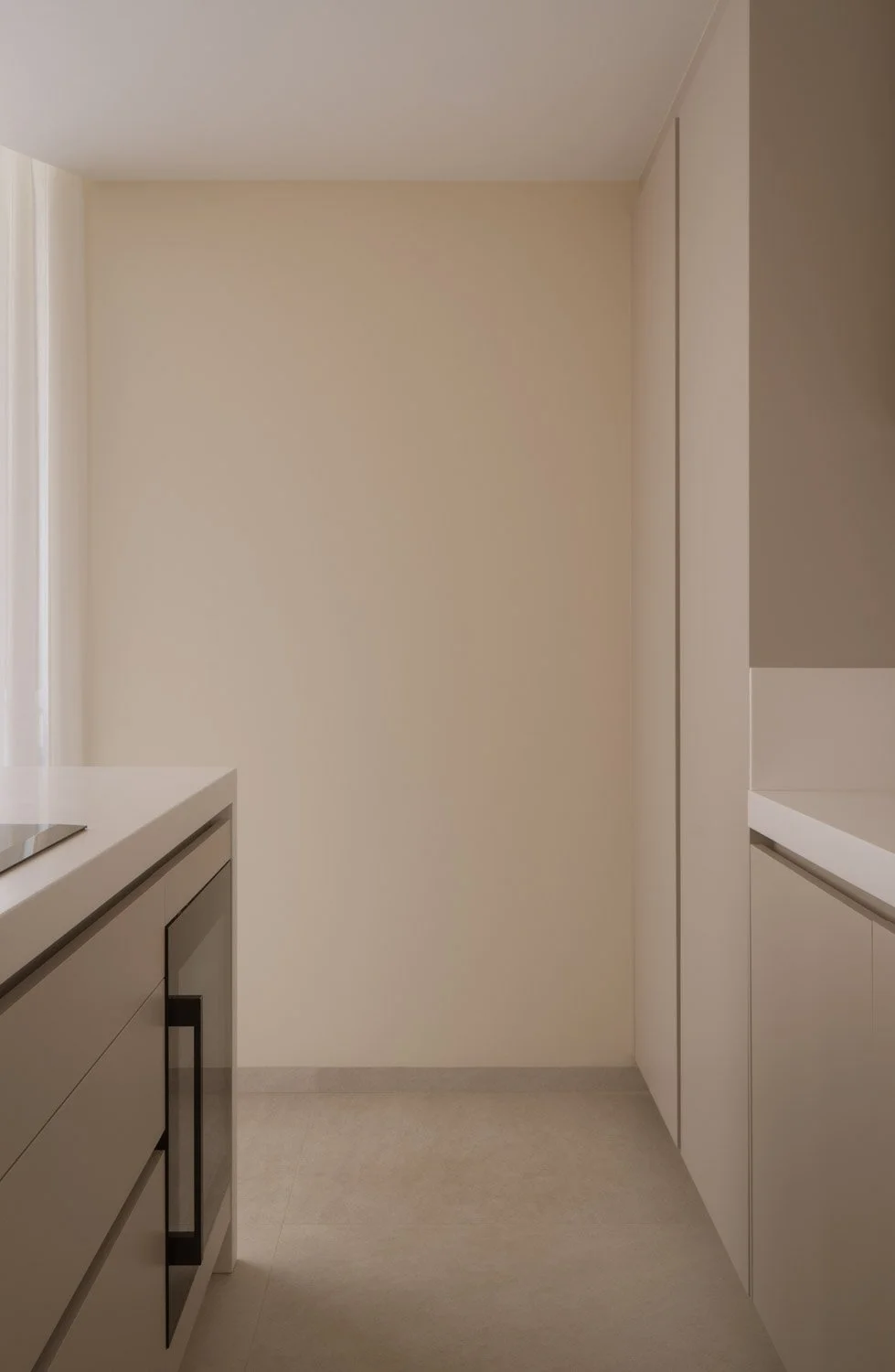Clean lines in a minimalist beige kitchen with integrated appliances.