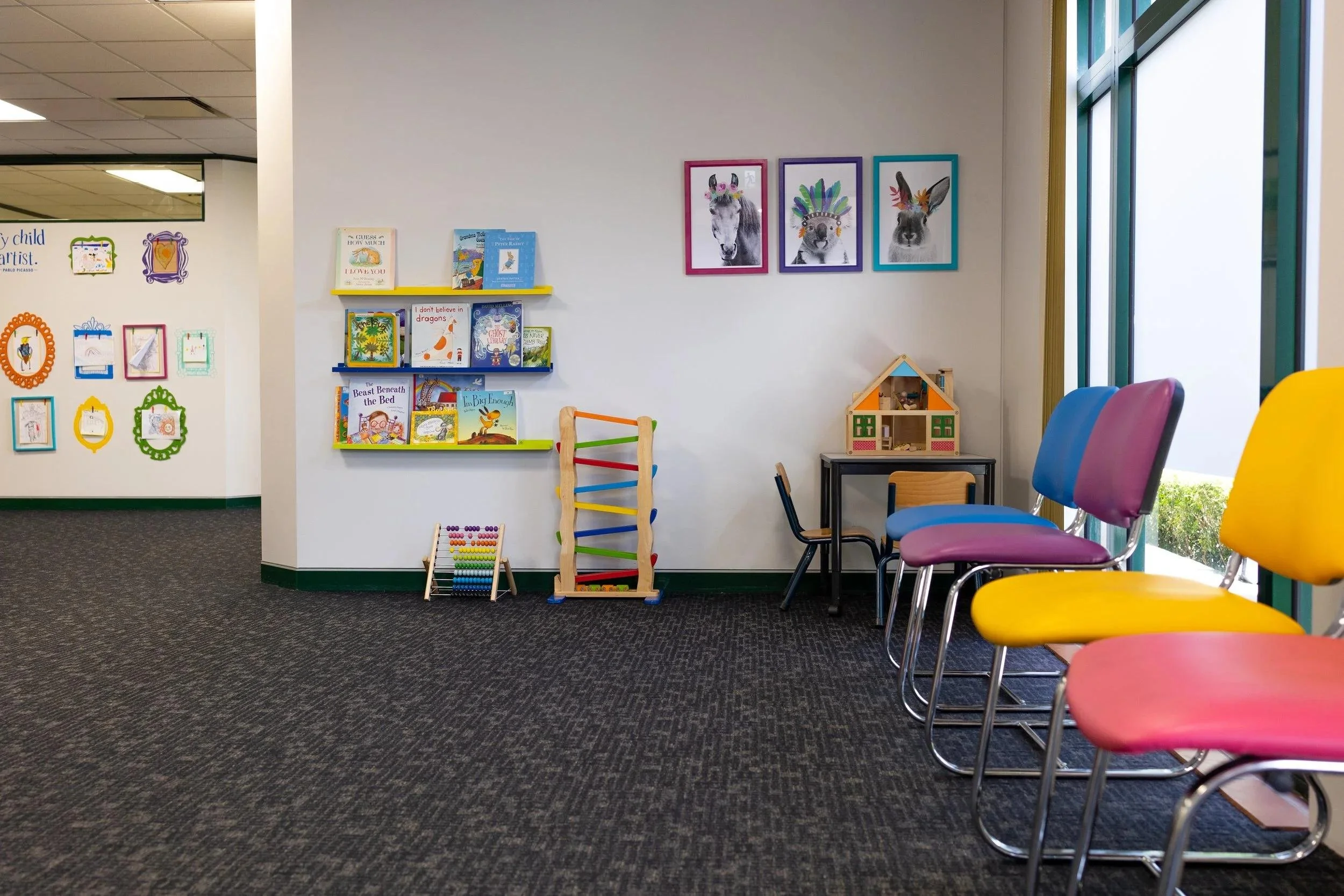 Bright child-friendly psychology waiting area with colorful chairs, children’s books, and toys.