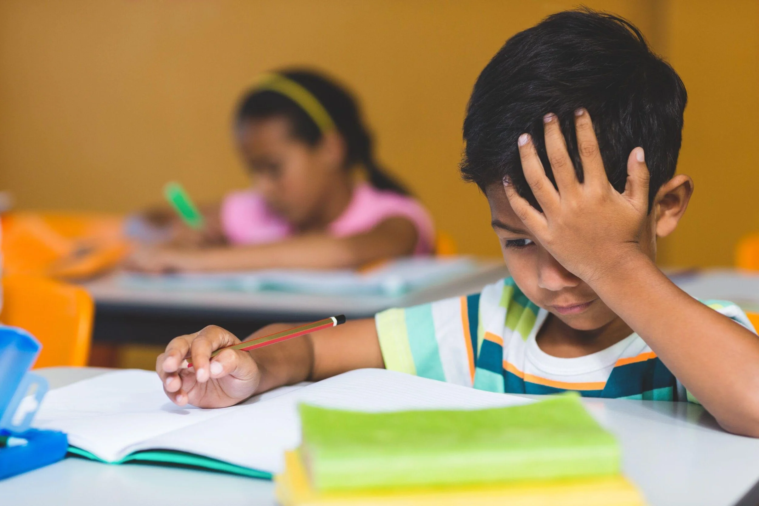Young student with dysgraphia looking frustrated.