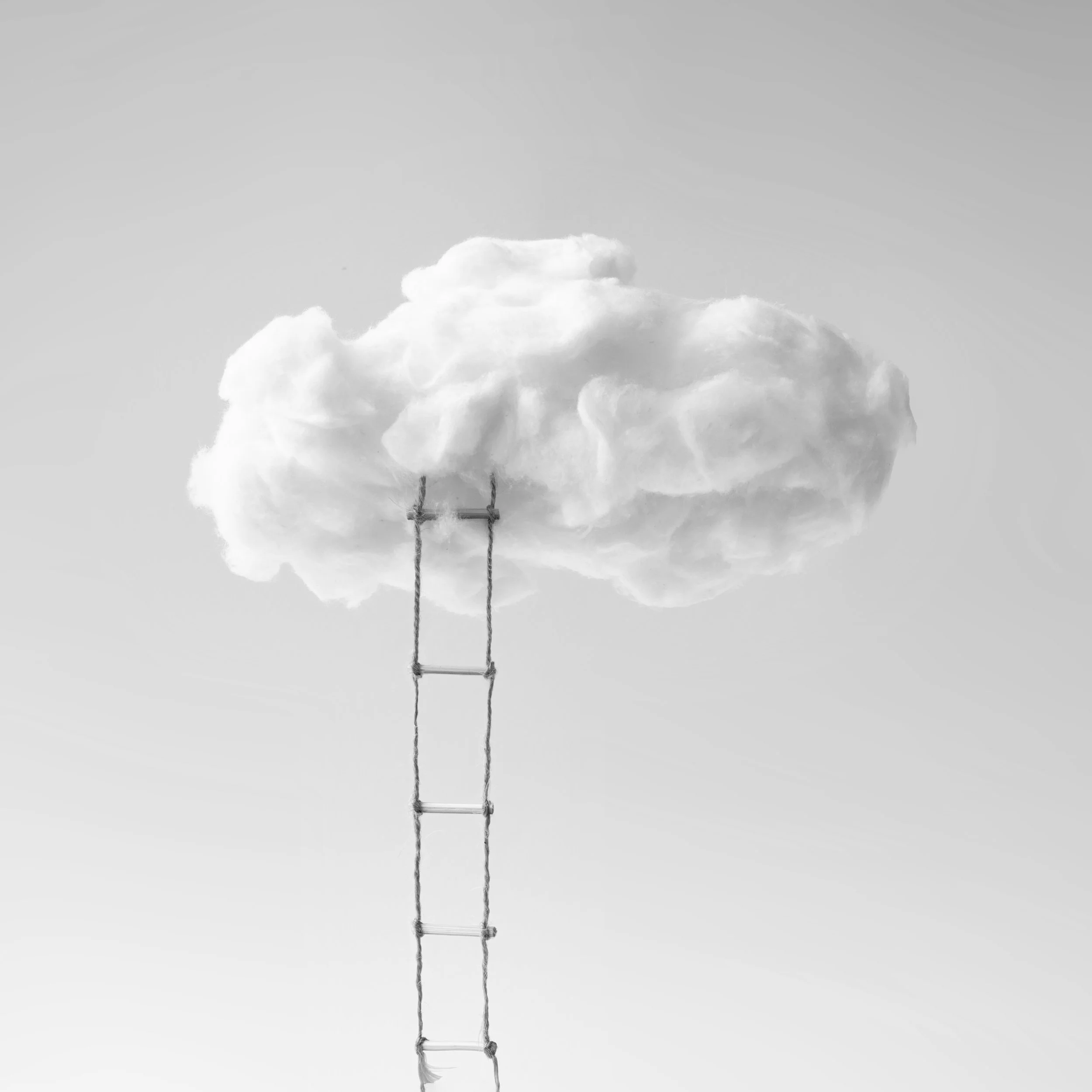 Black & white image of a cloud with a rope ladder leading up to it