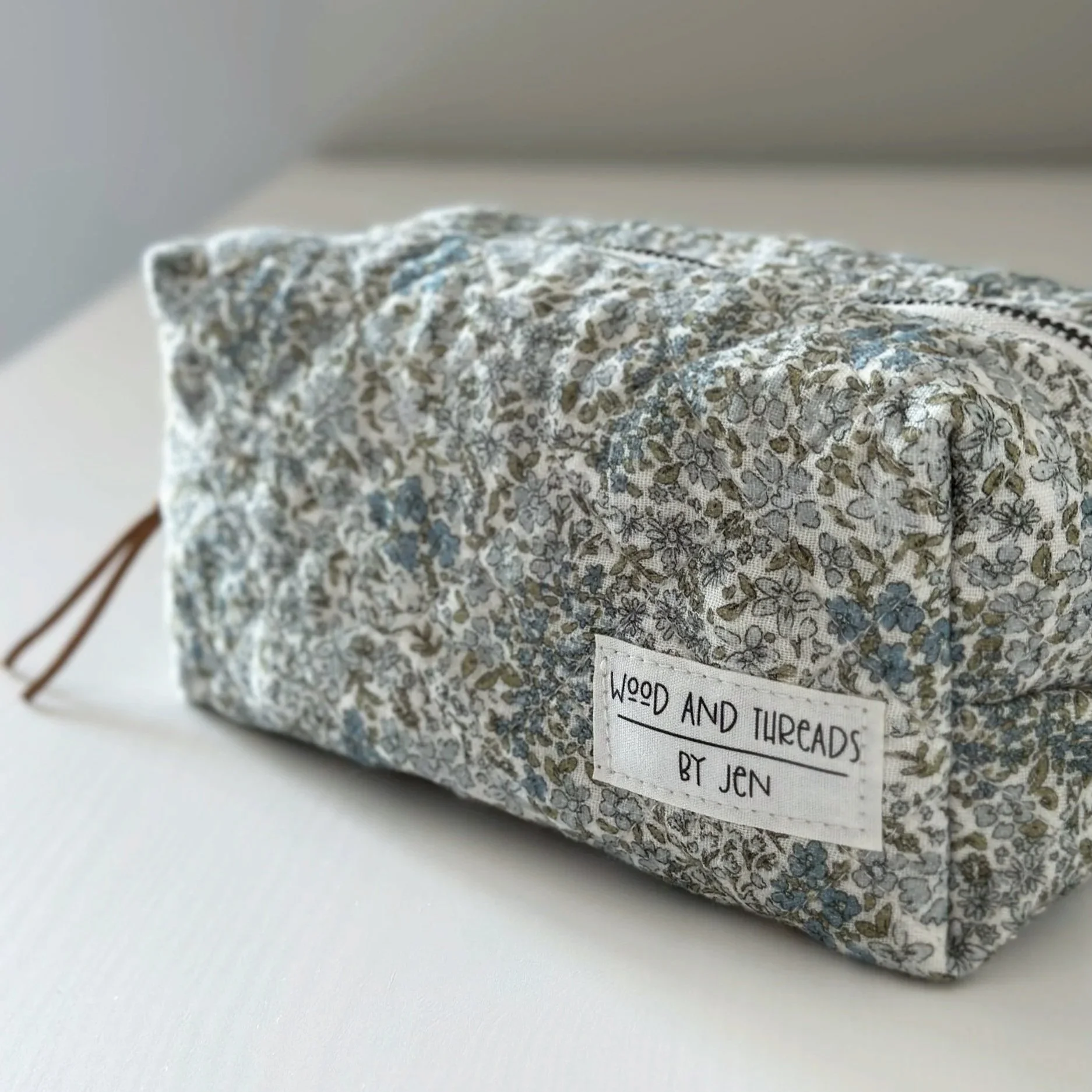 Green crosshatch quilted boxy pouch showing the Wood and Threads by Jen label