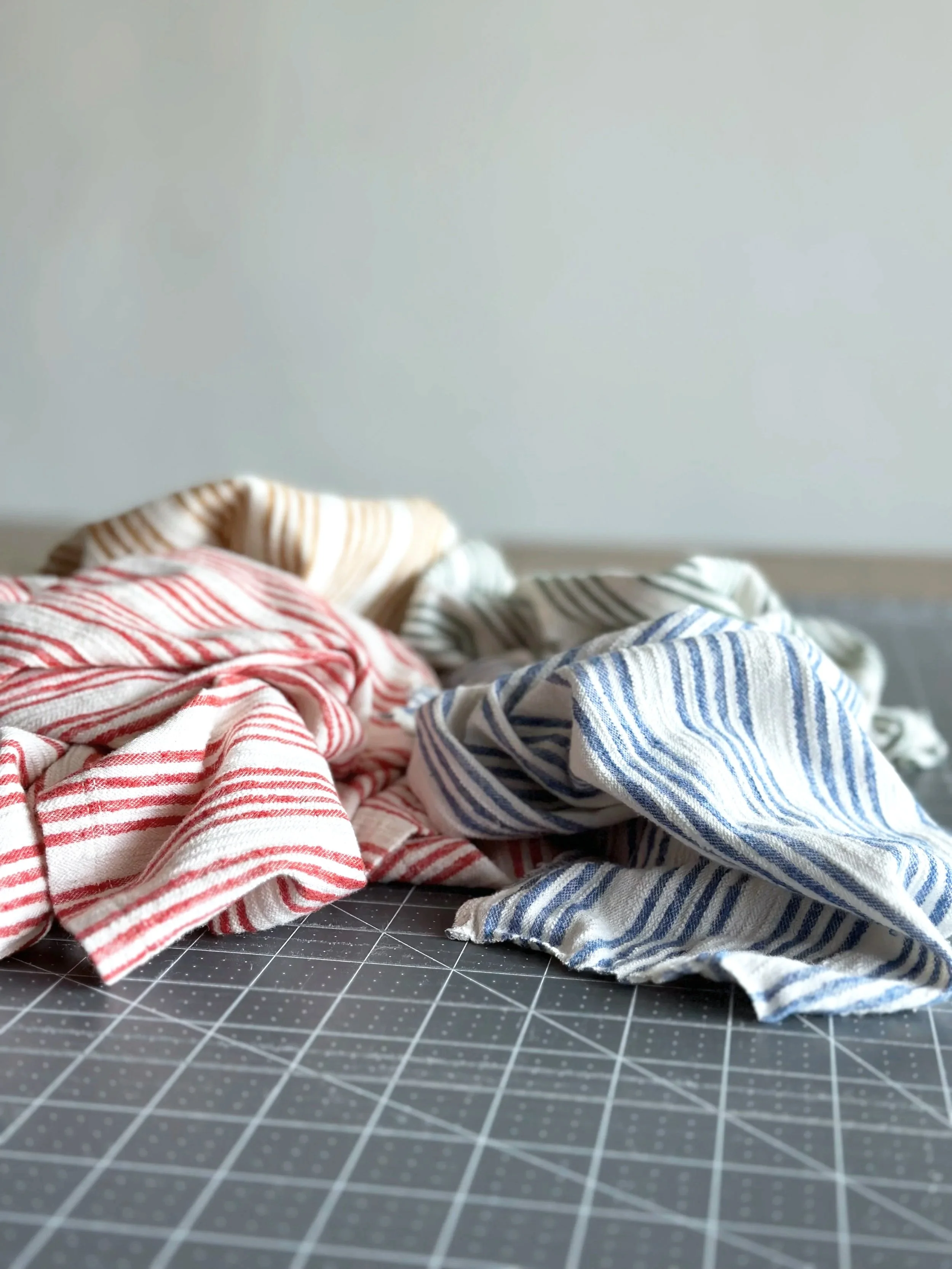  Striped cotton linen fabric cut from a thrifted dress, sorted by color and ready to sew — behind the scenes of The Thrift Edit handmade pouch collection 