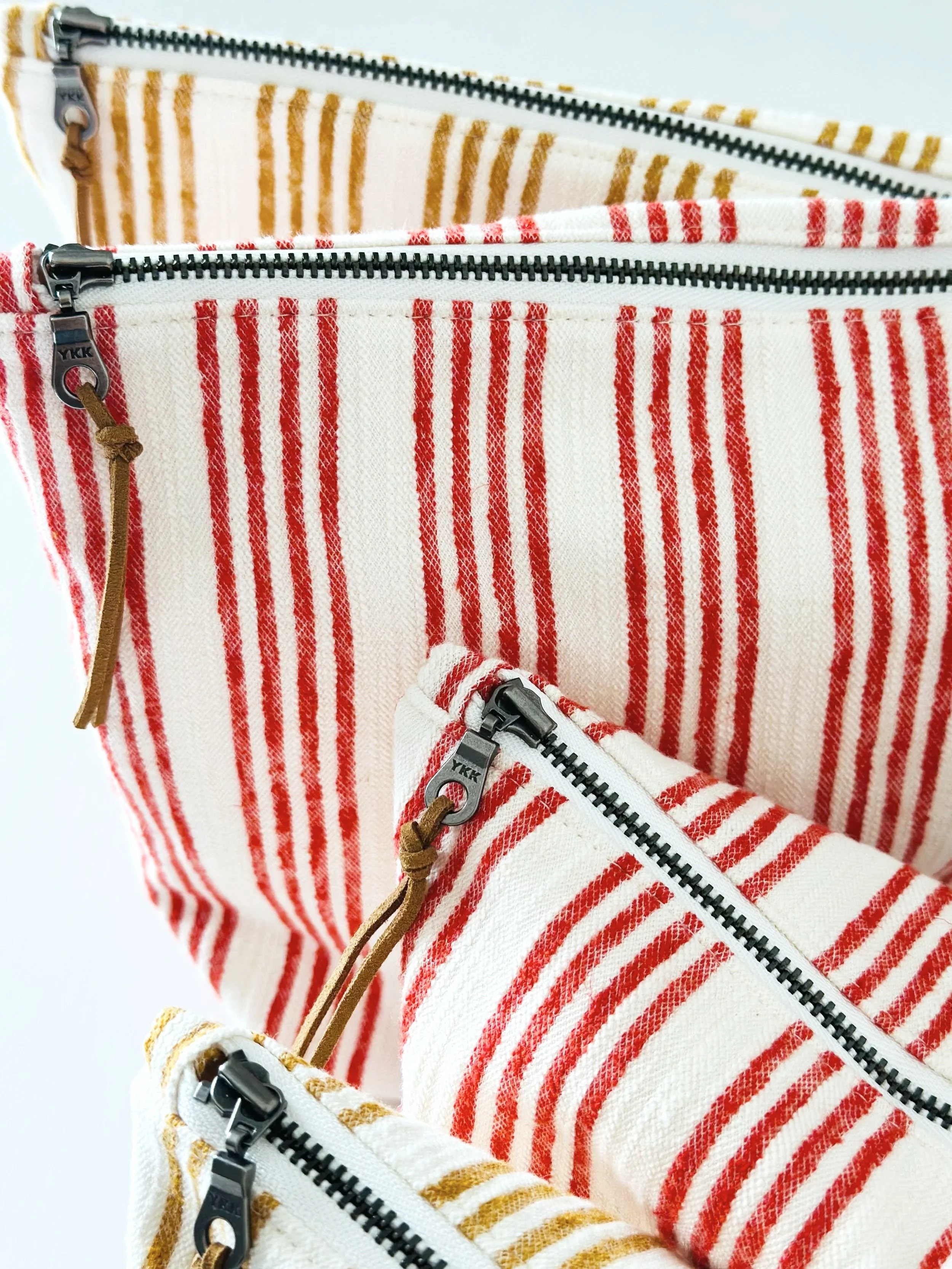  Handmade striped zipper pouch in muted red — upcycled from a thrifted dress. The Thrift Edit by Wood and Threads by Jen. 