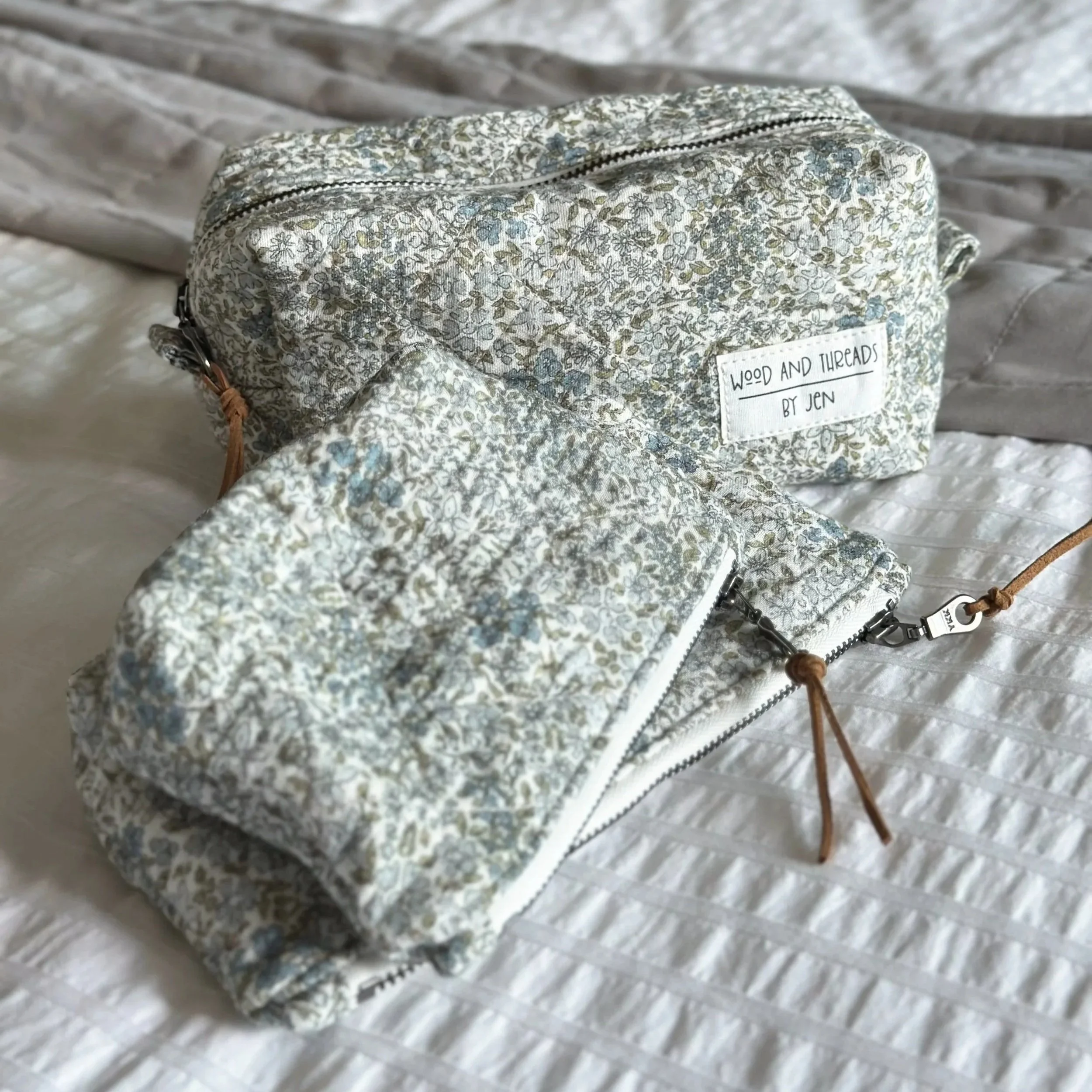 Green crosshatch quilted boxy pouch styled on a textured linen surface