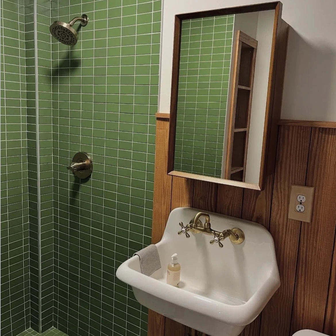 green titled shower with pine wainscoting on bathroom walls
