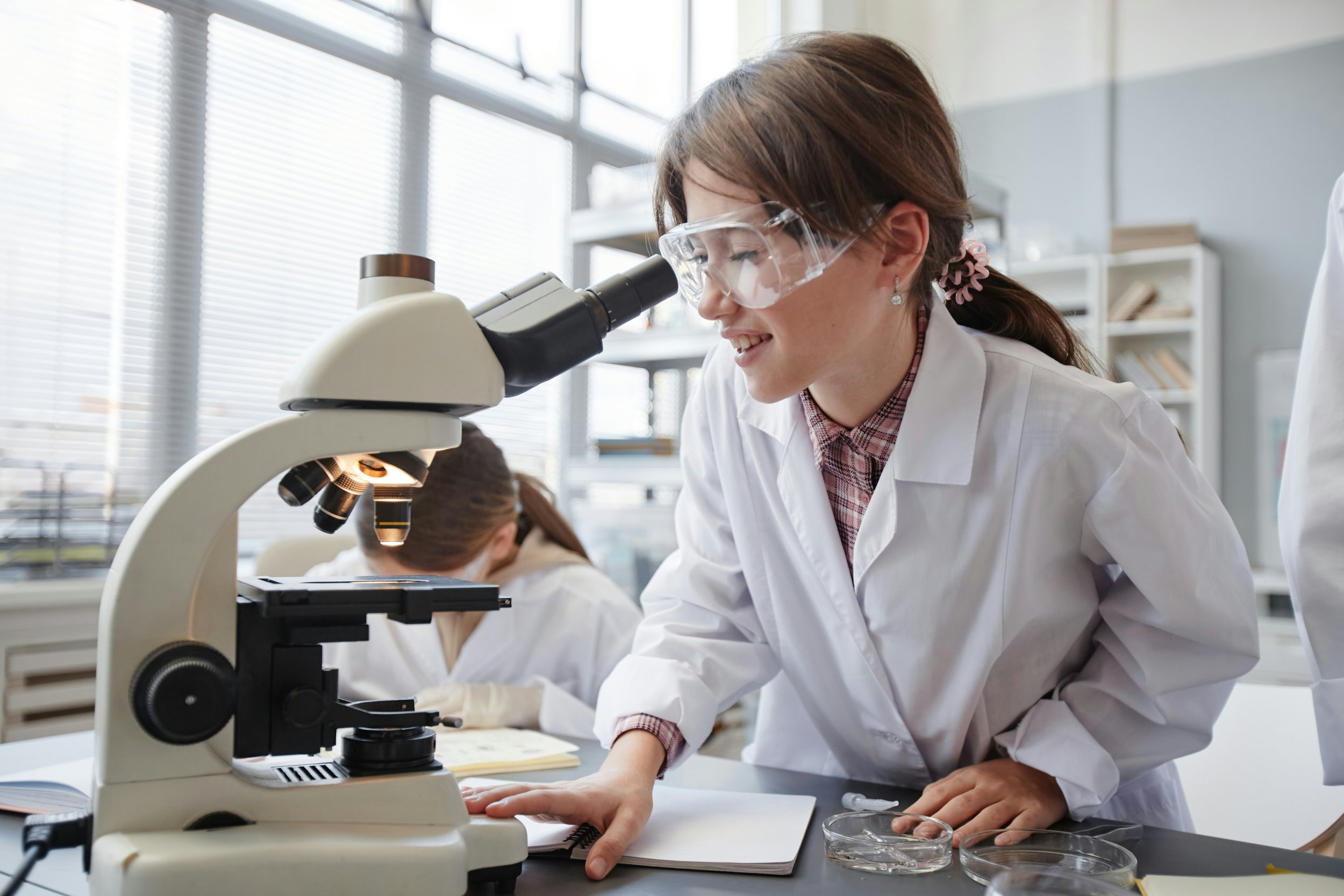 young female student looking through a microscope