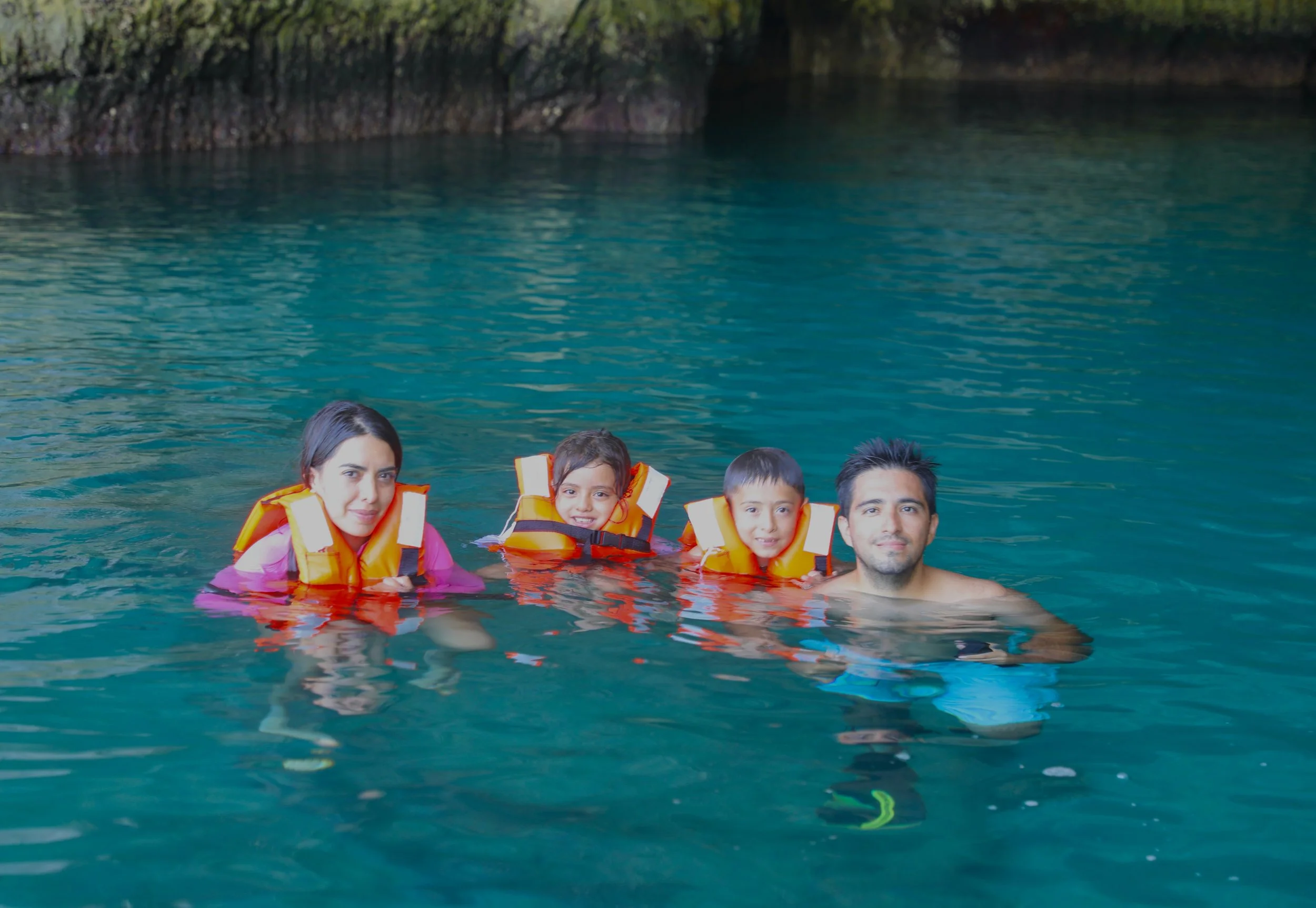 A family swimming in the crystal-clear waters of Loreto Bay National Park with Baja Adventures.