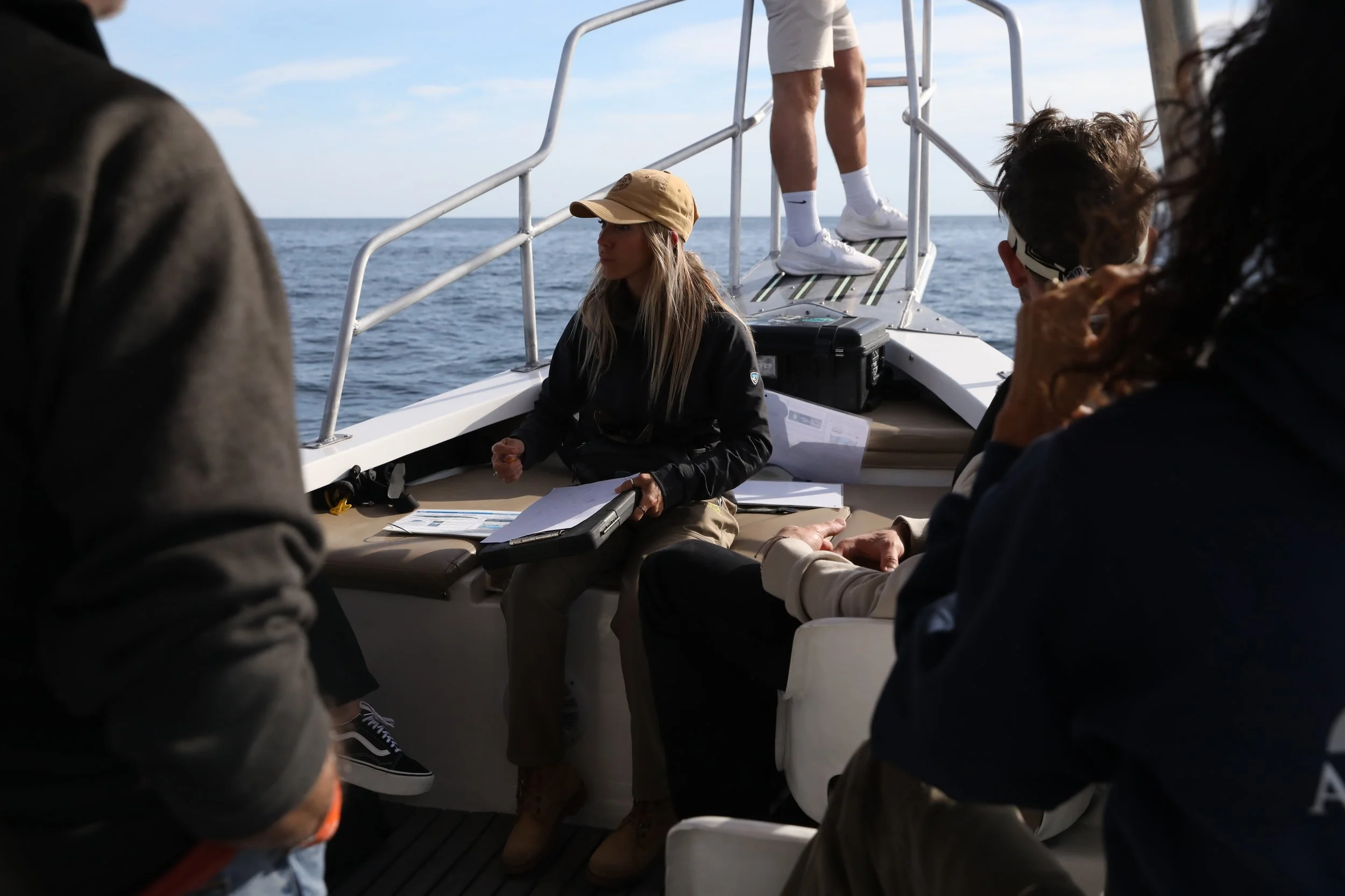 Expedition leader Regina Domingo collecting cetacean data with citizen-science participants during a whale expedition in Loreto