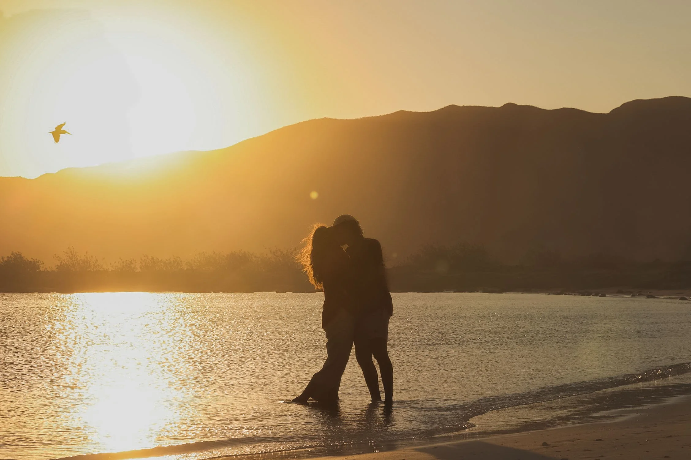 Romantic couple celebrating their engagement at sunset during a private marriage proposal adventure in Loreto, Mexico.