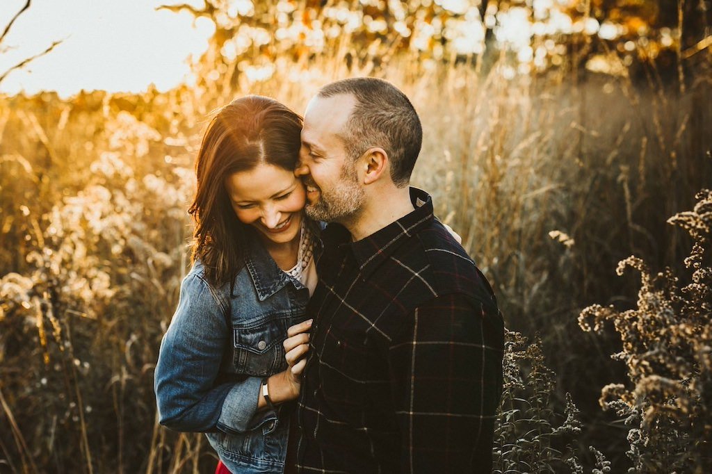 Husband and wife embracing lovingly in Acacia Park in Beachwood, Ohio.