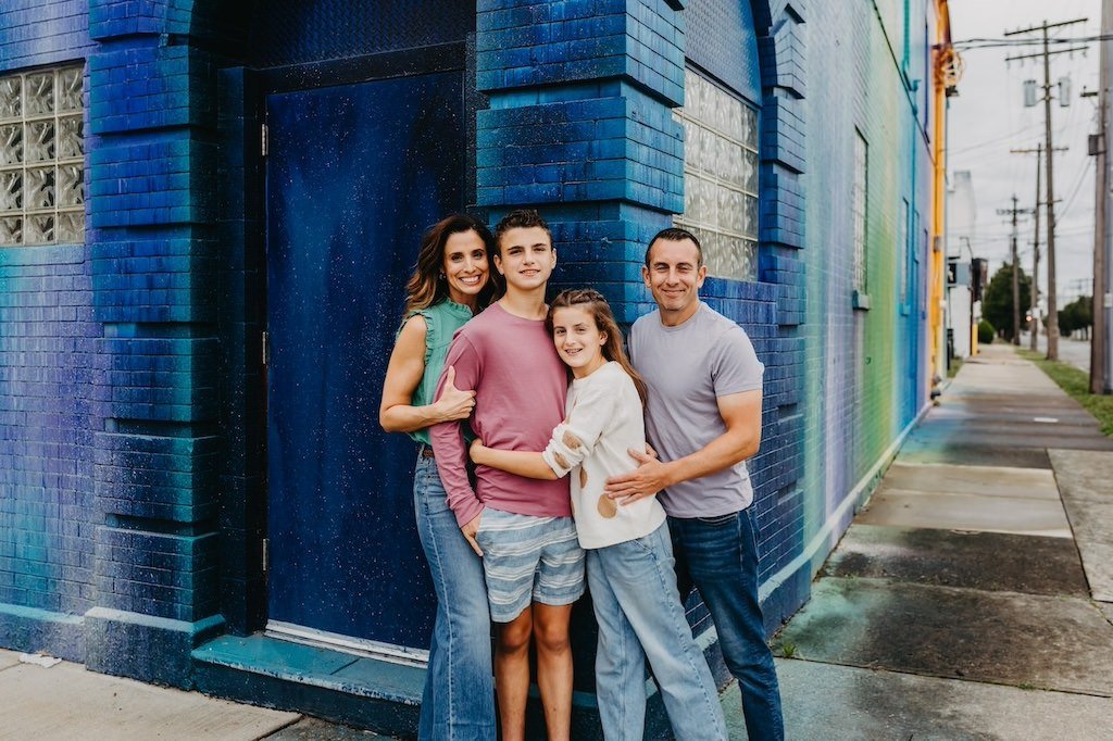 Family of 4 posing in-front of rural mural in Cleveland, Ohio downtown. 