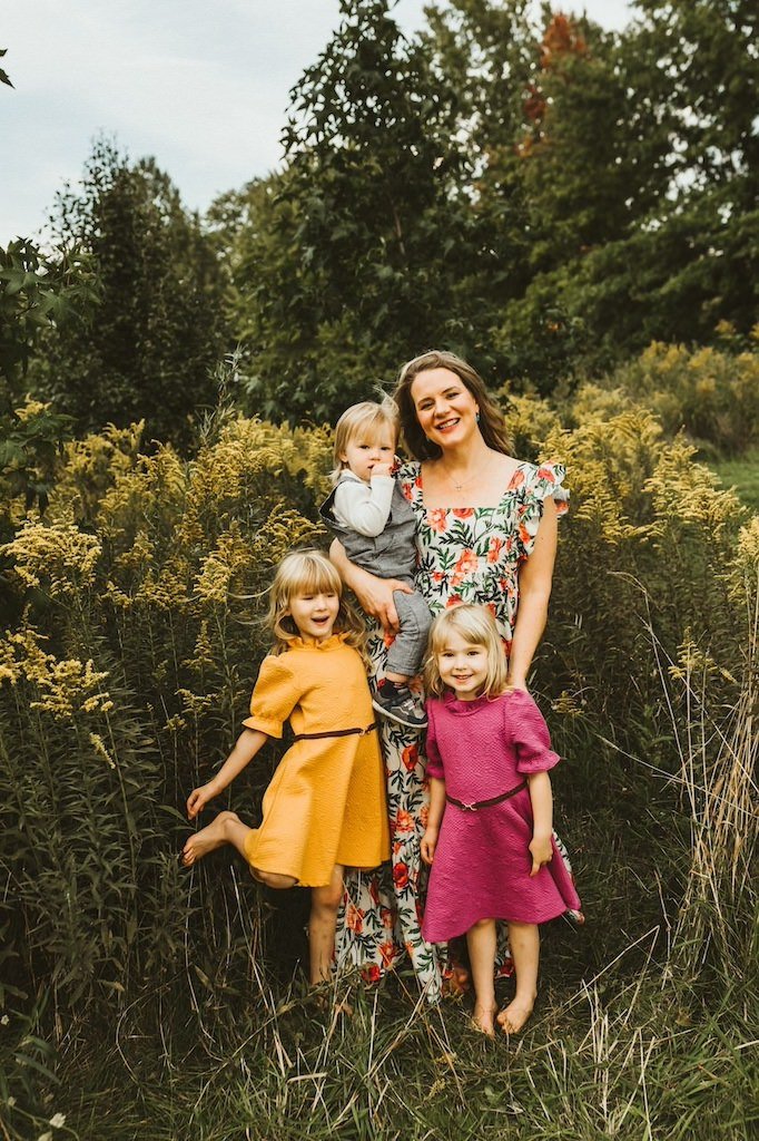 Mom and three kids smiling for a picture in the fall at Acacia Reservation. 