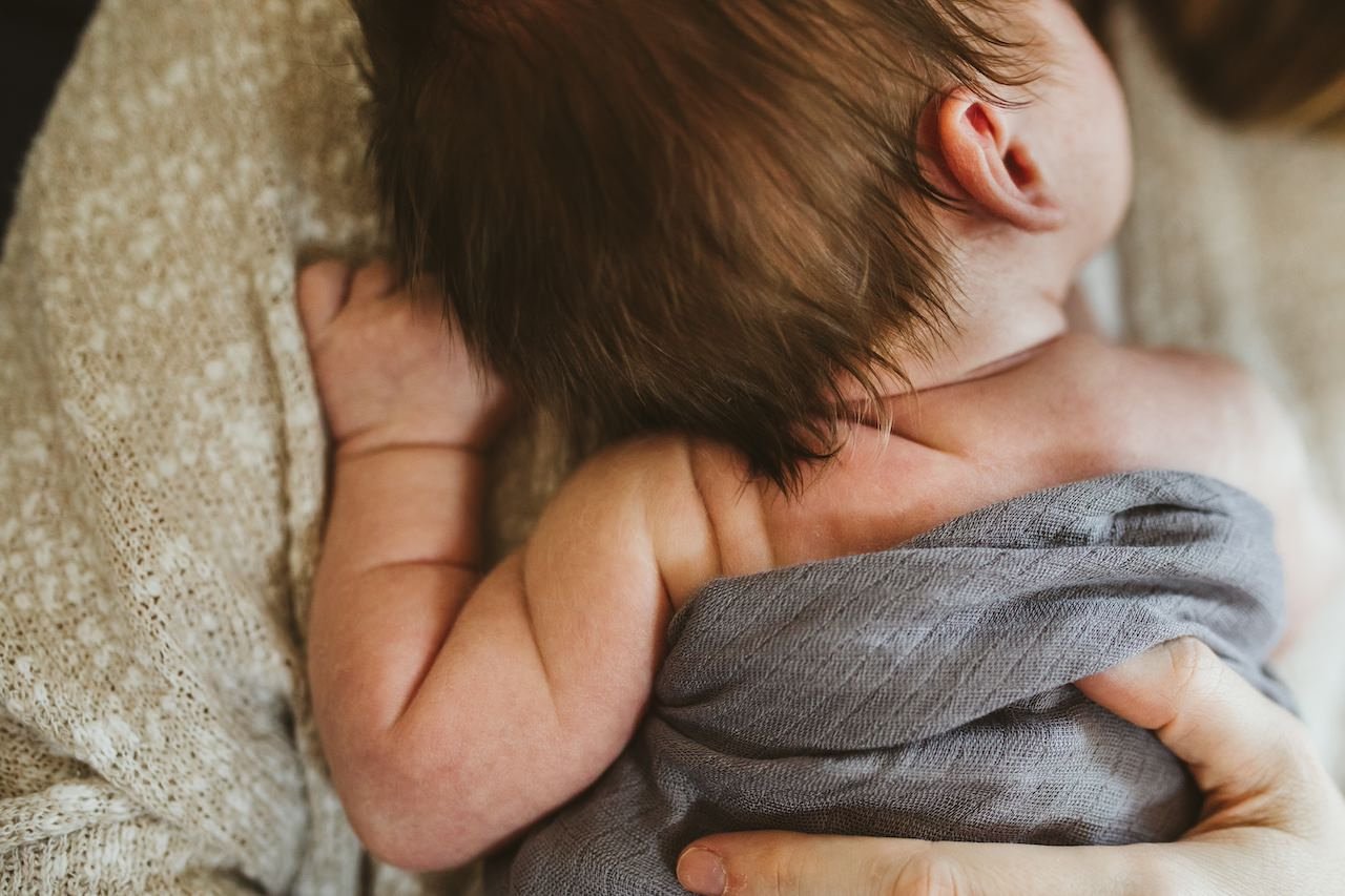 A 2 week old newborn arm rolls photographed during a newborn shoot. 