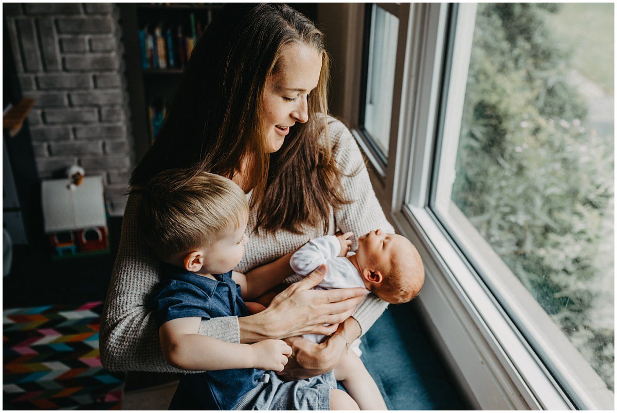 Mom and two brothers cuddling during a newborn shoot in Cleveland Heights. 