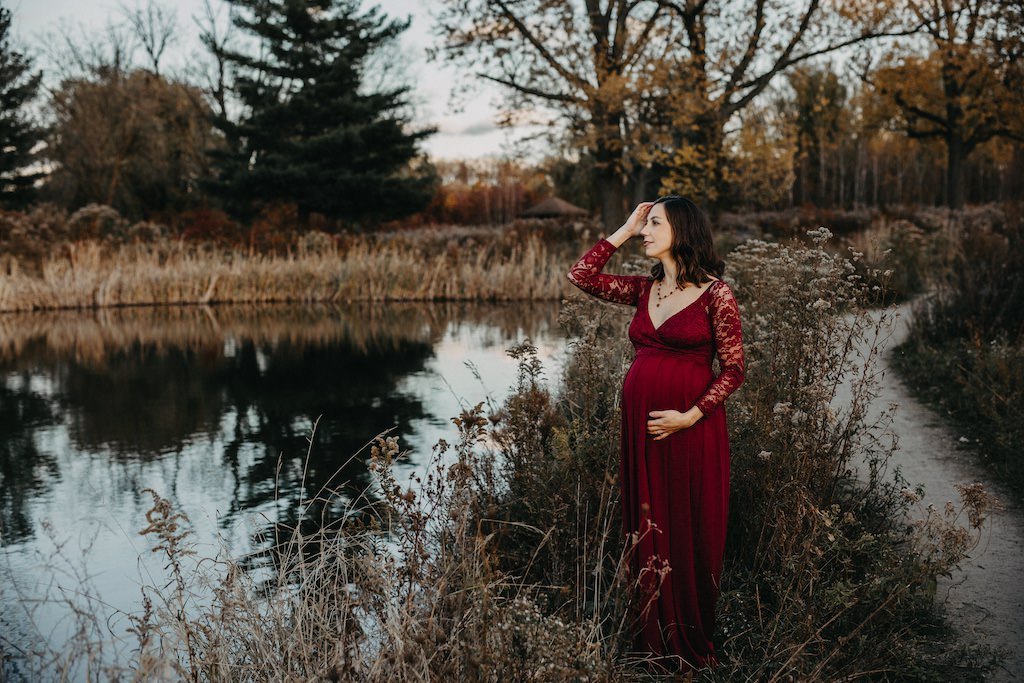 A pregnant mother to be posing in the fall season wearing red dress in Cleveland, Ohio.