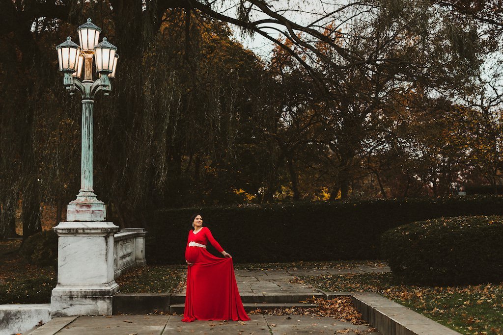 Pregnant woman wearing a red dress in Wade Lagoon Cleveland, Ohio.
