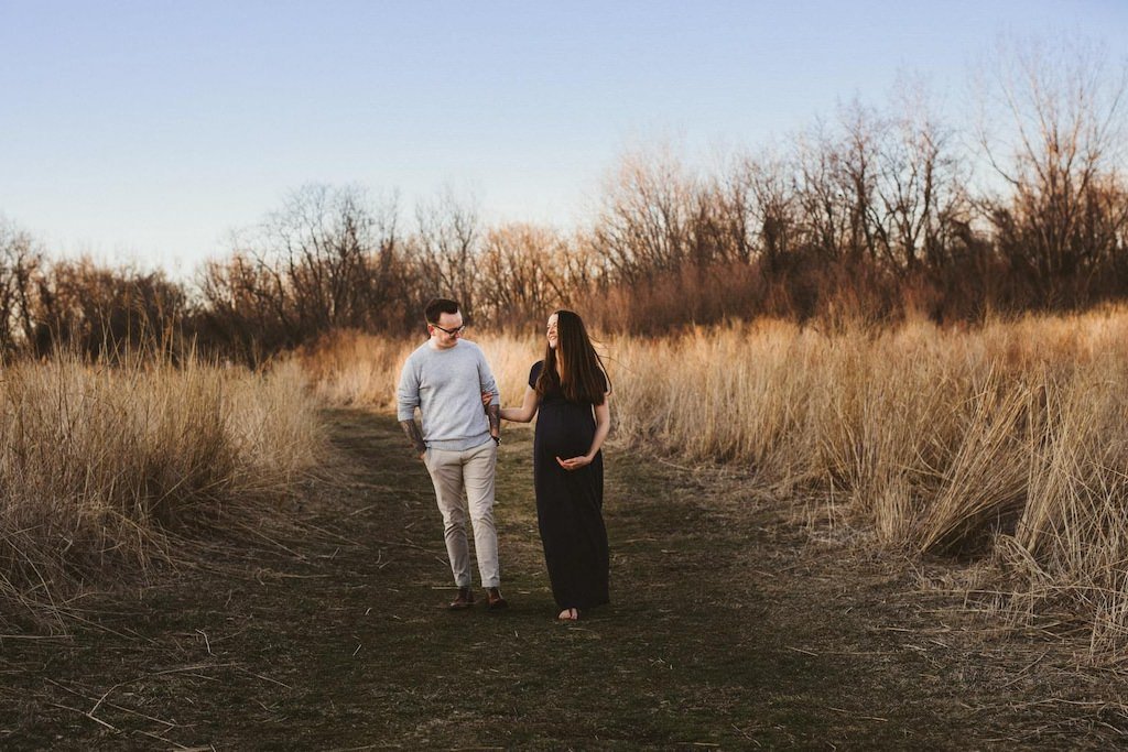 Pregnant wife and husband walking in park trail in Cleveland Ohio for a maternity session.