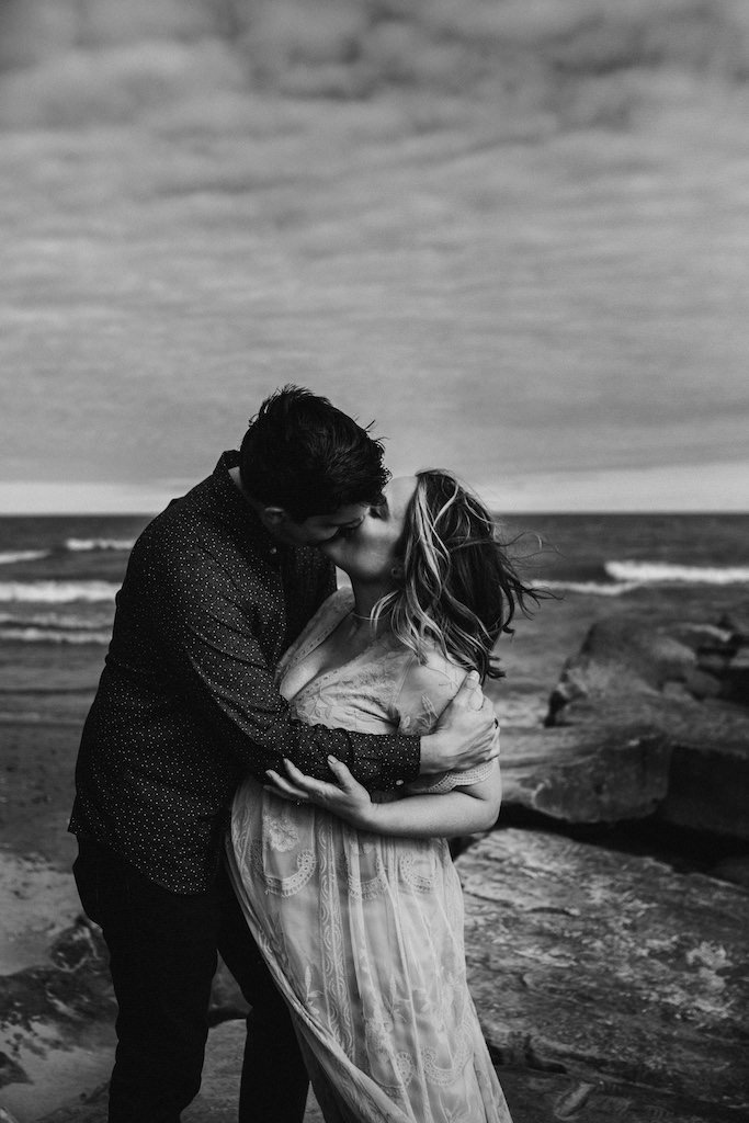 Couple kissing in Huntington Beach for a picture during a maternity lifestyle session. 