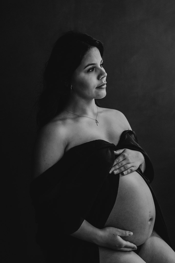 Pregnant mother to be posing for black and white portrait in Cleveland, Ohio photography studio. 
