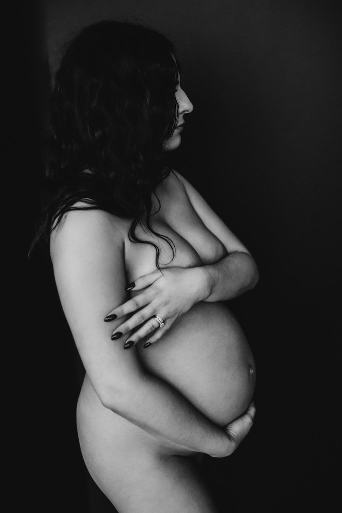 Tasteful nude portrait of pregnant woman in a photography studio. 