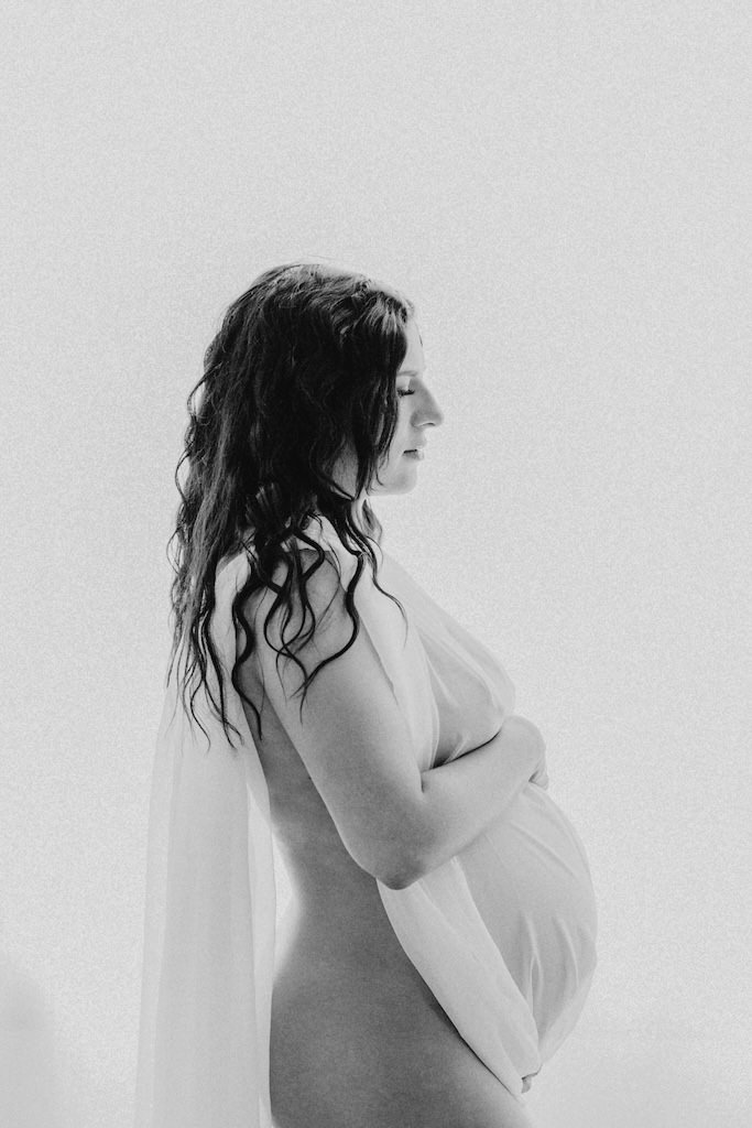 Backlit photo of woman during a maternity session in Cleveland, Ohio portrait studio. 