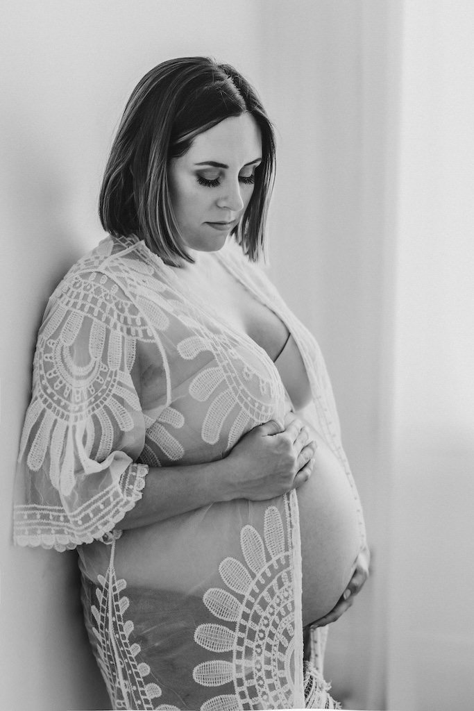 Pregnant woman wearing a transparent robe covering her pregnant body in Cleveland, studio. 