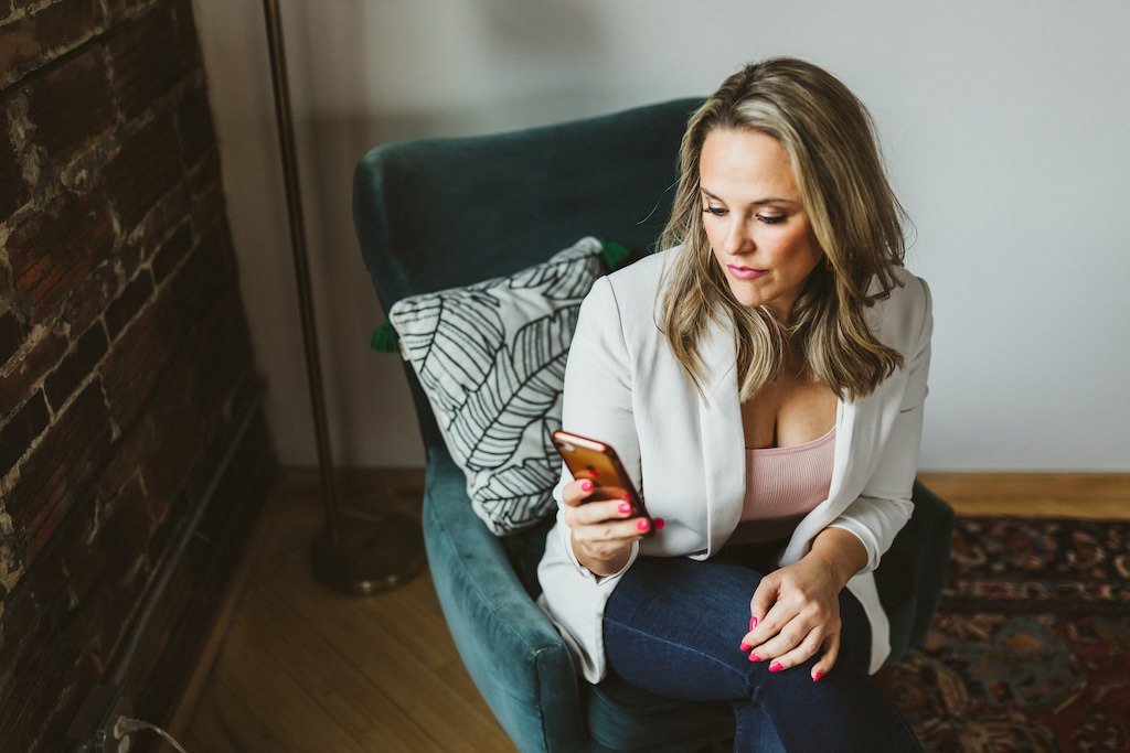 Small business owner looking at cell phone during a personal branding photo shoot. 