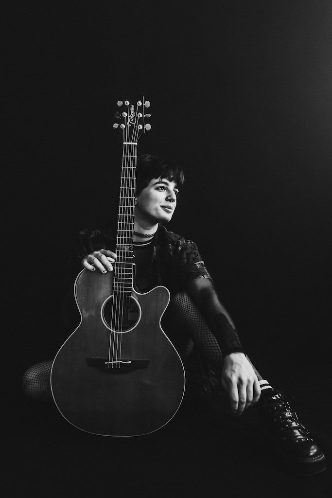 Black and white branding shoot of woman wearing boots and holding guitar in Cleveland, Ohio. 