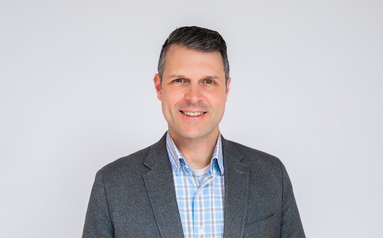 Professional headshot of man in blazer against white backdrop in Cleveland, Ohio studio. 