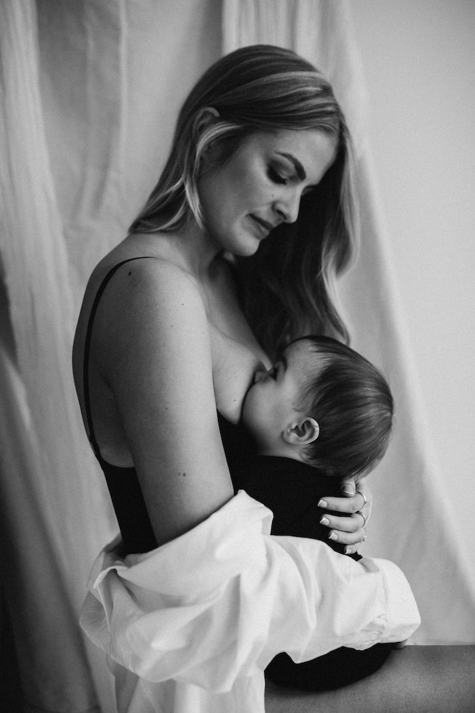 A black and white photo of mother breastfeeding infant daughter in Cleveland studio.