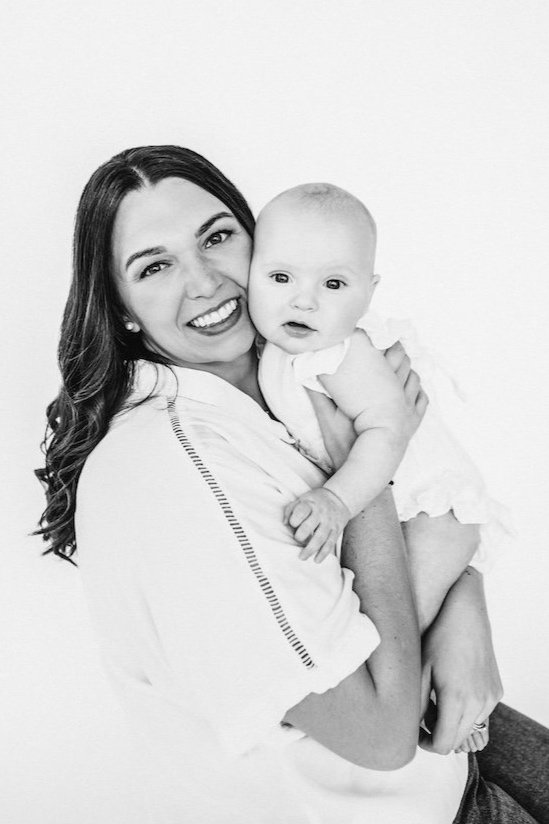 A black and white portrait of mom and daughter agains white backdrop in Cleveland studio. 
