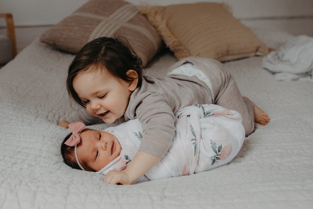 Baby sister with big brother during a newborn shoot.