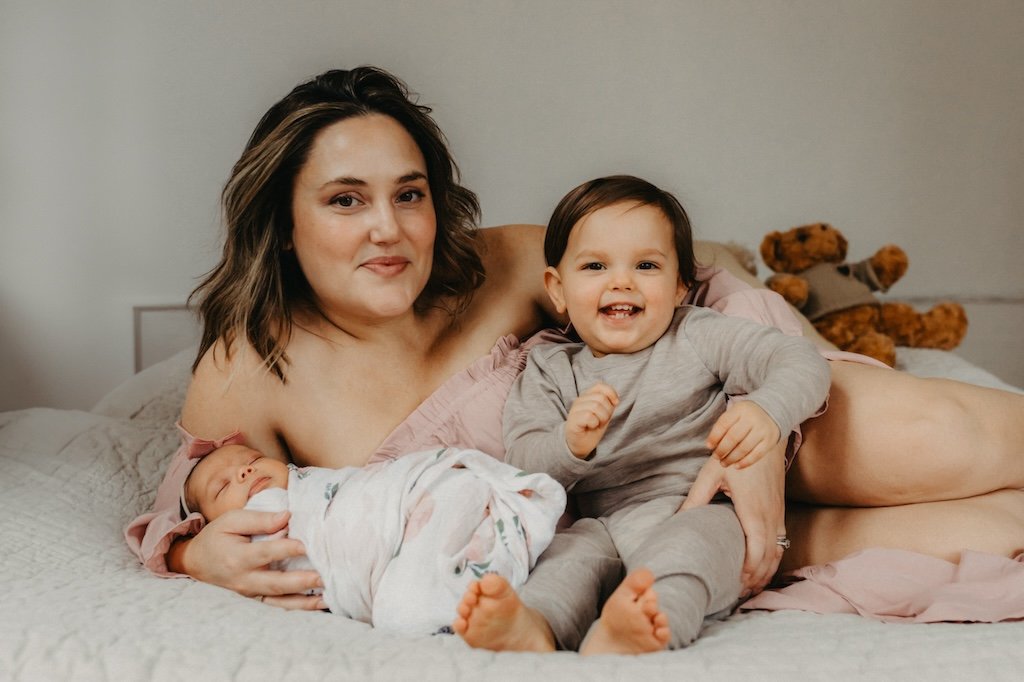 Mom wearing pink off shoulder dress for baby pictures. 